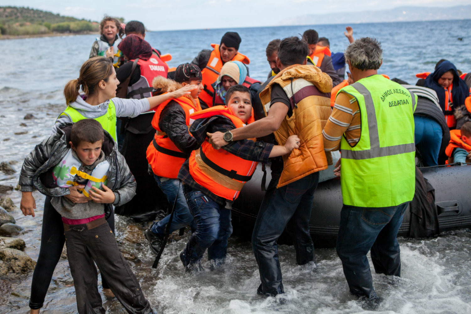 Uprchlíci vystupují z gumového člunu na řeckém ostrově Lesbos