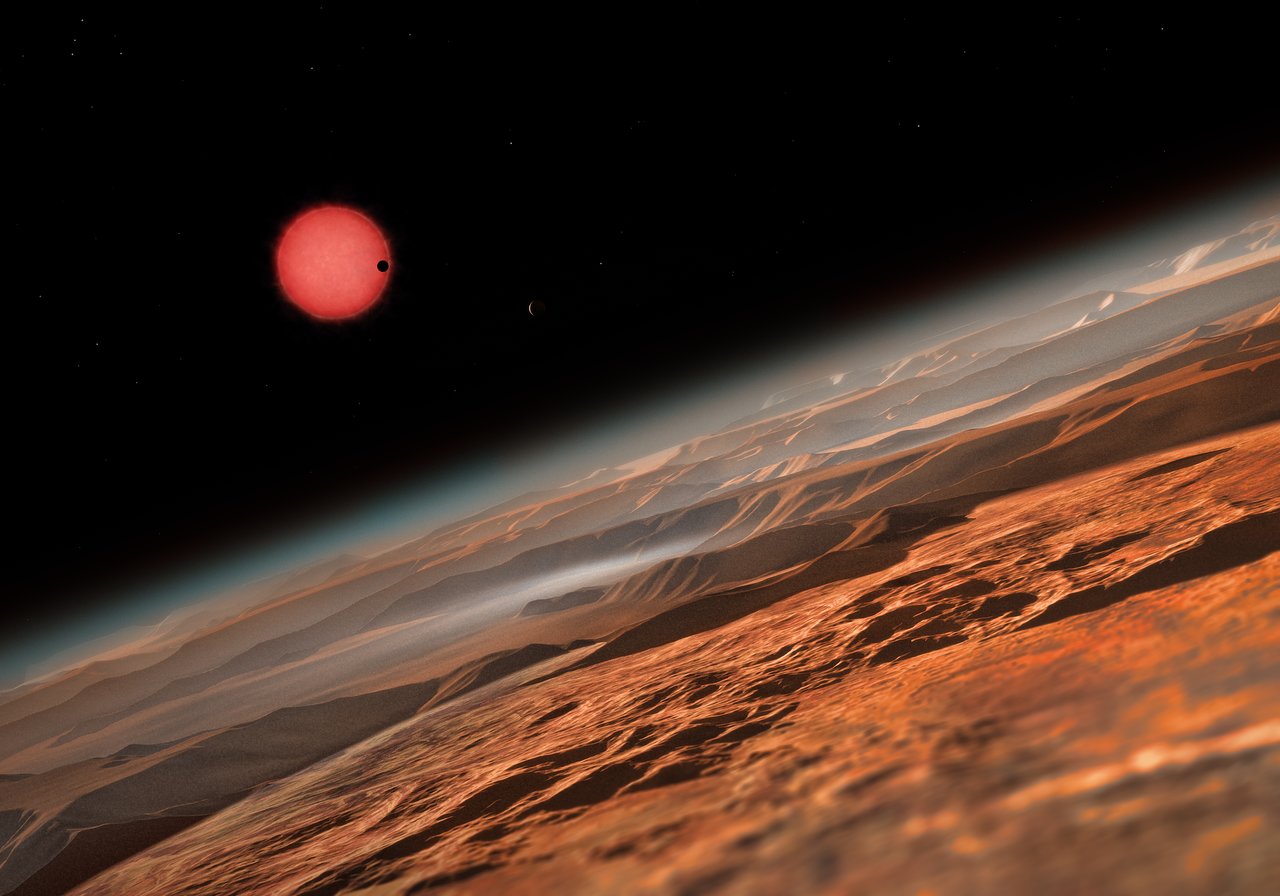 Chladná trpasličí hvězda TRAPPIST-1 při pohledu z oběžné dráhy kolem jedné z jejich planet, v představě výtvarníka