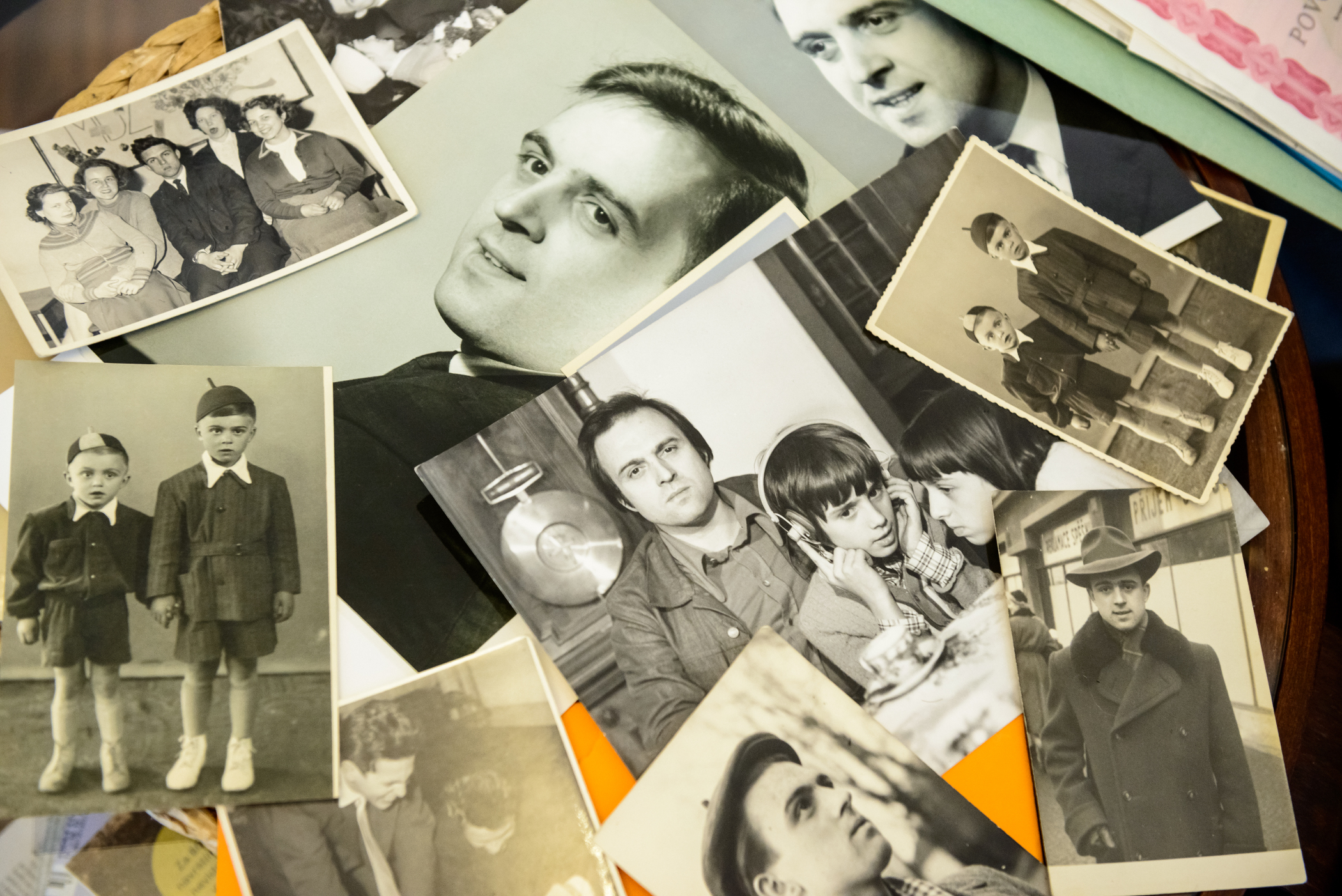 Milena ukazuje fotografie svého otce, zcela vlevo je fotografie Jiřího Gruši z dětství, spolu s jeho bratrem