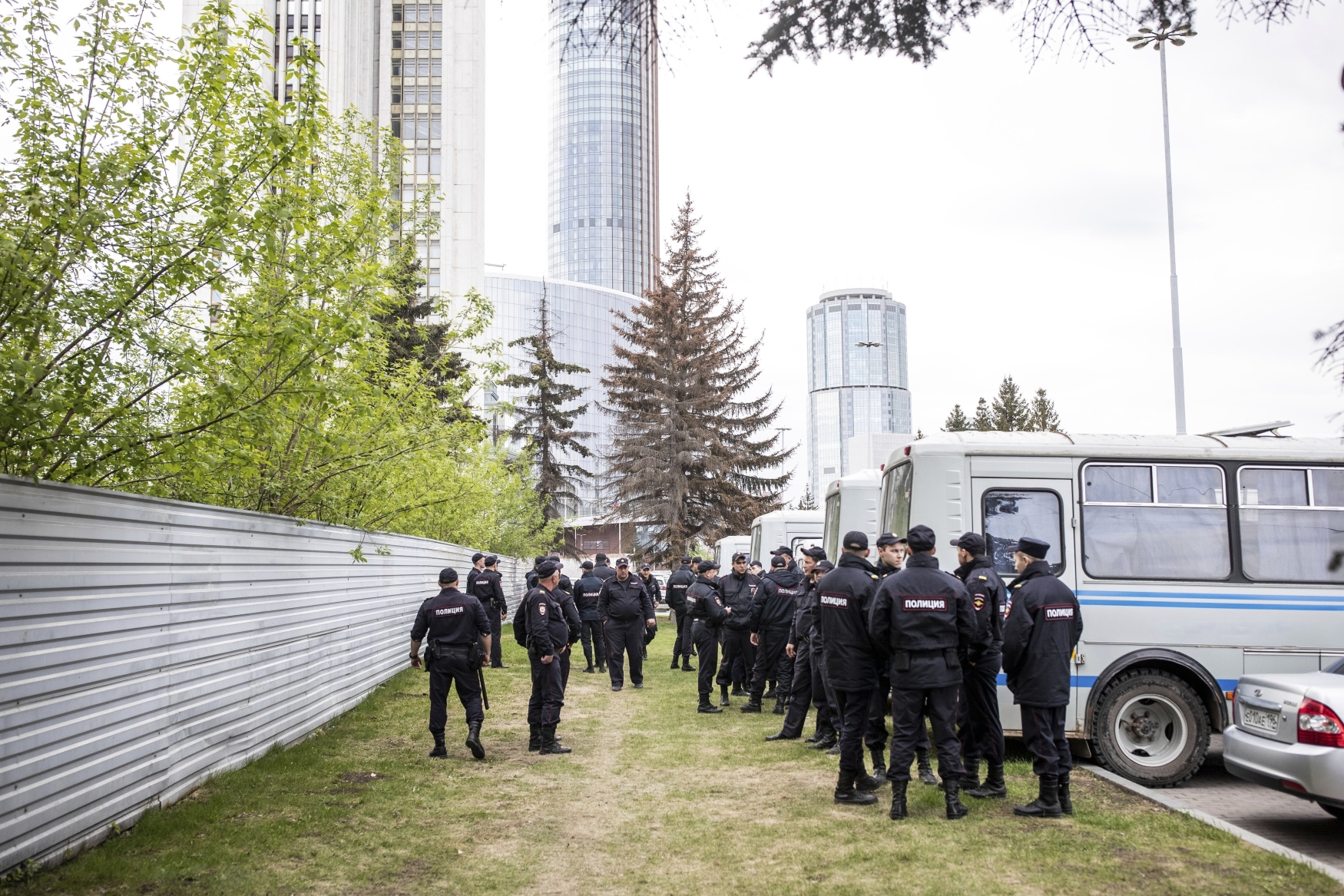 Policisté před plotem blokují demonstranty, kteří protestují proti plánům na výstavbu katedrály v parku v ruském Jekatěrinburgu