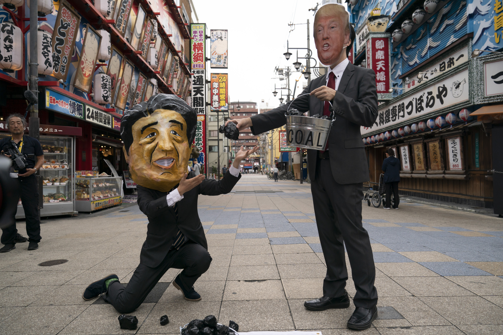 Aktivisté v maskách japonského premiéra Šinza Abeho a amerického prezidenta Donalda Trumpa protestují proti používání uhlí