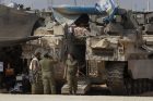 Příslušnice izraelské armády před obrněným transportérem v jižním Izraeli