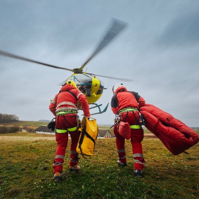 Záchranáři s bezpečnostním postrojem a horolezeckým vybavením běží k vrtulníku záchranné služby | foto: Shutterstock