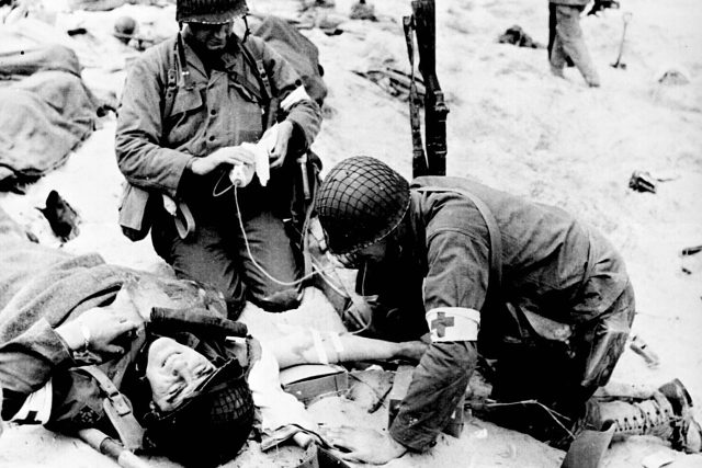 Ošetřování zraněného vojáka ve Francii,  1944 | foto:  National Archives and Records Administration