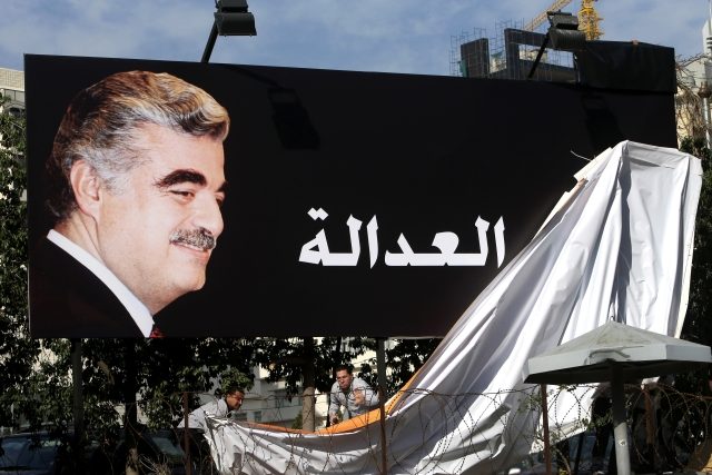 Příznivci bývalého libanonského premiéra Rafíka Harírího v Bejrútu odhalují plakát s jeho fotografií a nápisem &quot;Spravedlnost&quot; jen několik set metrů od místa,  kde byl zavražděn | foto: Hussein Malla,  ČTK