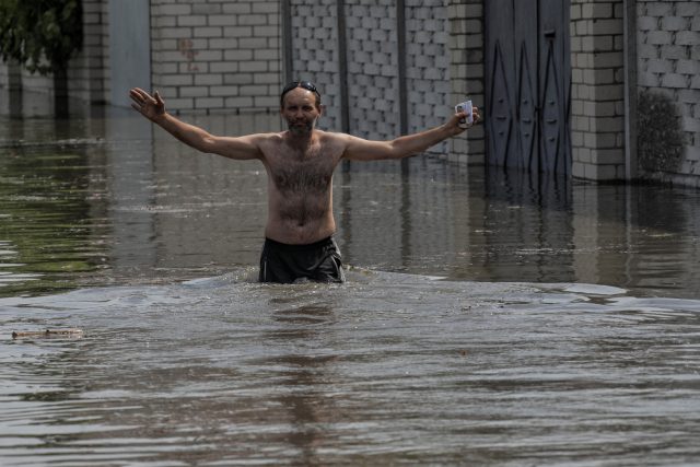 Obyvatel Chersonu se brodí zatopenou ulicí poté,  co výbuch zničil hráz nádrže Nová Kachovka. | foto:  Agentura Reuters,  Reuters