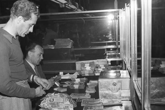 Měnová reforma v Československu v roce 1953. Bankovní úředníci přepočítávají staré peníze. | foto: Viktor Lomoz,  ČTK
