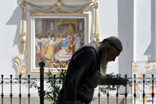 Mnich před freskou v Kyjevě | foto:  Sergei Supinsky,  Profimedia / AFP