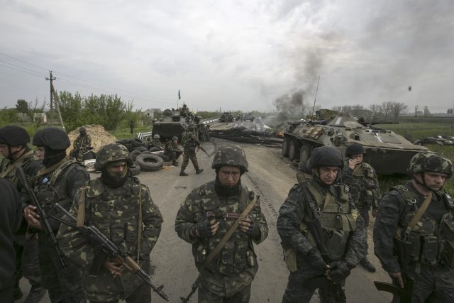Ukrajinští vojáci stojí na stráži na ukrajinském kontrolním stanovišti poblíž města Slovjanks na východě země | foto: Baz Ratner,  Reuters