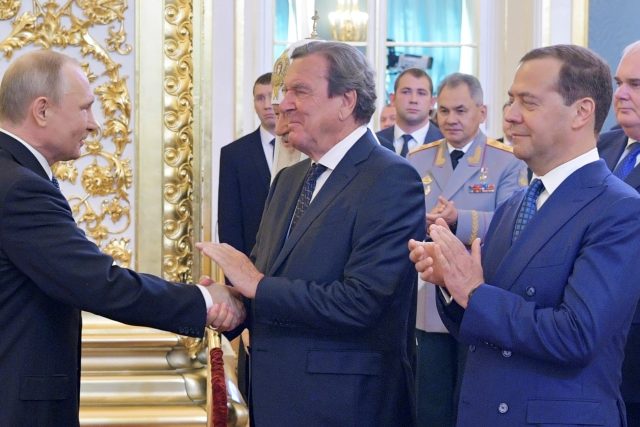 Poslední inaugurace Vladimira Putina  (2018). Rukou mu potřásá Gerhard Schröder,  vedle něj stojí Dmitrij Medveděv | foto: Reuters