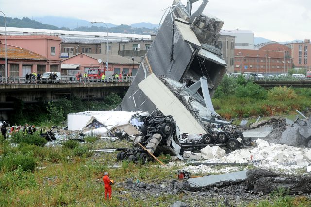 Během neštěstí se z mostu zřítila auta včetně nákladních,  mezi nimiž byl také vůz pražského přepravce SPED-IT. Řidič kamionu pád přežil | foto: Reuters