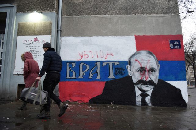 Malba ruského prezidenta Putina na zdi domu v Bělehradě. Nad původní nápis „bratr“ někdo červeným sprejem dopsal „vrah“. | foto: REUTERS/Zorana Jevtic,  Reuters