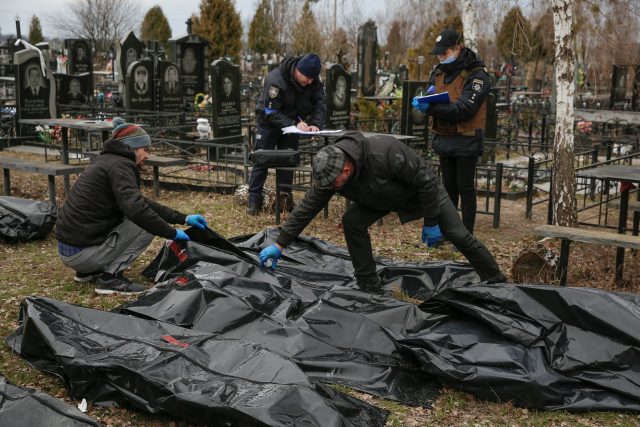 Pohřební služba prohledává a identifikuje mrtvé ve městě Buča | foto: Oleg Pereverzev,  Reuters