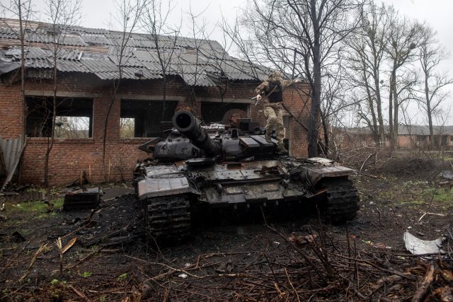 Ukrajinský voják seskakuje ze zničeného ruského tanku ve vesnici Mala Rogan na východě Ukrajiny | foto: Alkis Konstantinidis,  Reuters