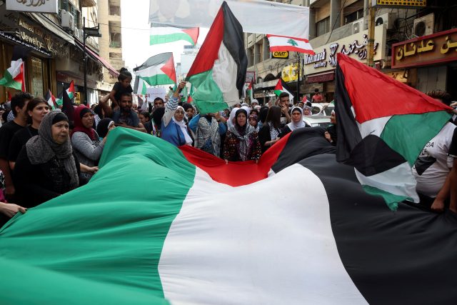 Lidé nesou vlajky během pochodu na vyjádření solidarity s Palestinci v Gaze | foto: Mohamed Azakir,  Reuters