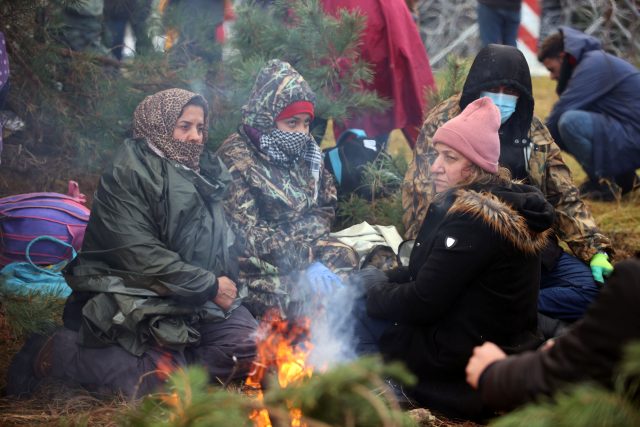 Skupina žen na bělorusko-polské hranici se snaží zahřát u ohně | foto: Reuters