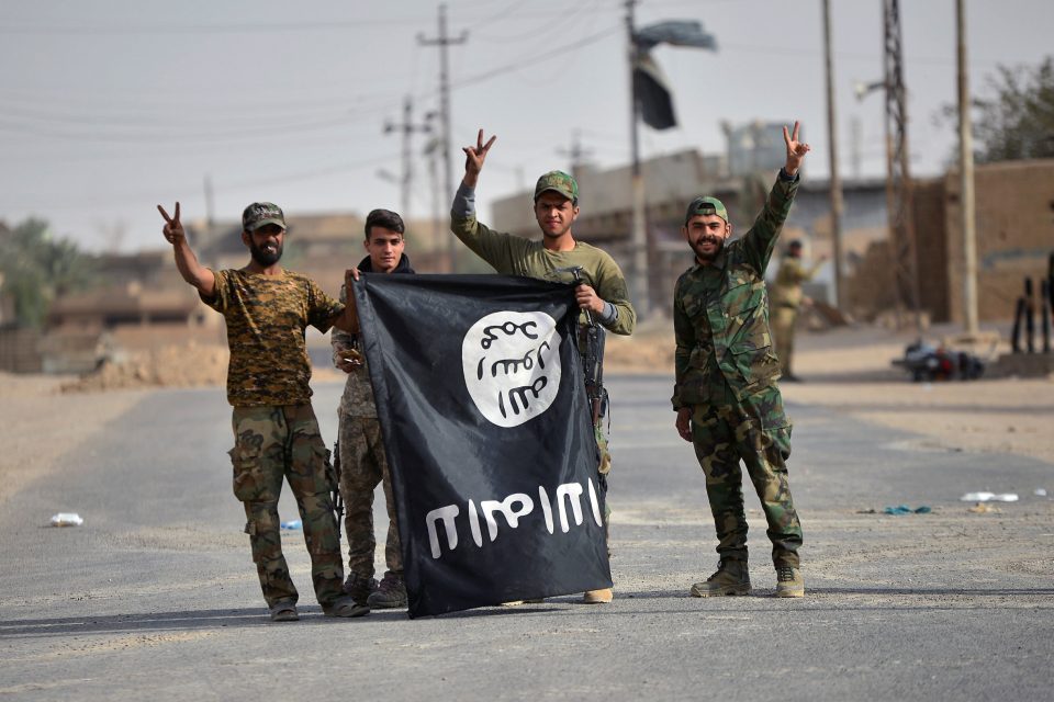 Šíitští milicionáři s vlajkou Islámského státu oslavují vítězství nad extremisty. | foto: Reuters