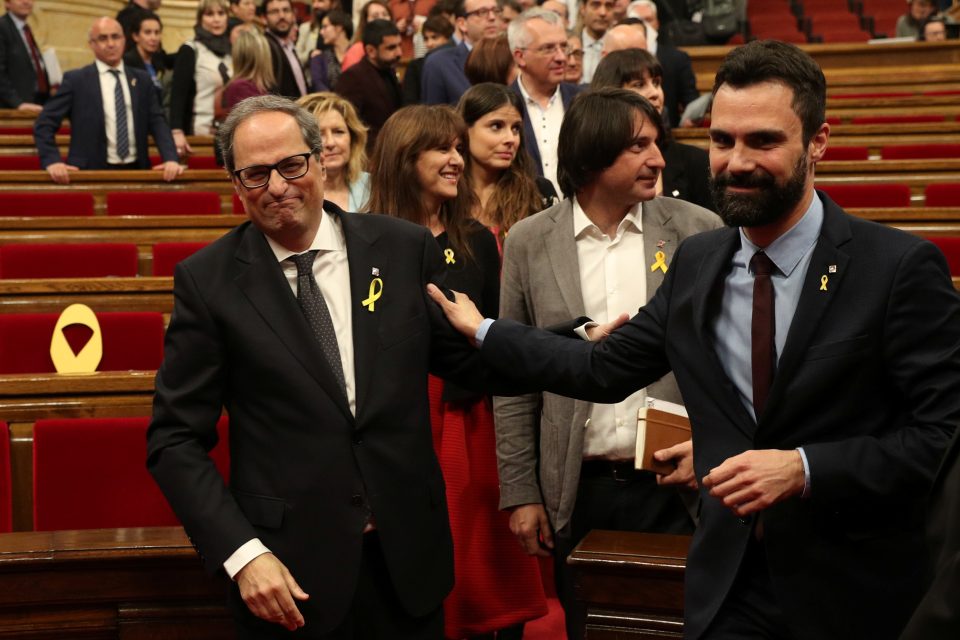 Katalánský premiér Quim Torra přijímá po zvolení v regionálním parlamentu gratulace od kolegů. | foto: Albert Gea,  Reuters