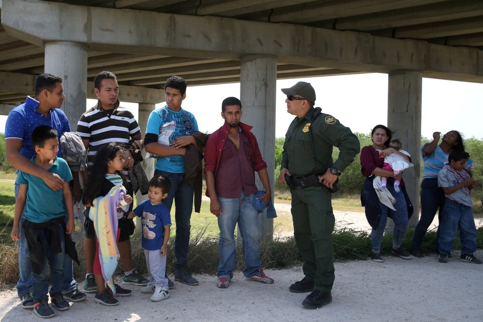Americký policista mluví s Mexičany,  kteří nelegálně překročili hranice | foto: Loren Elliott,  Reuters
