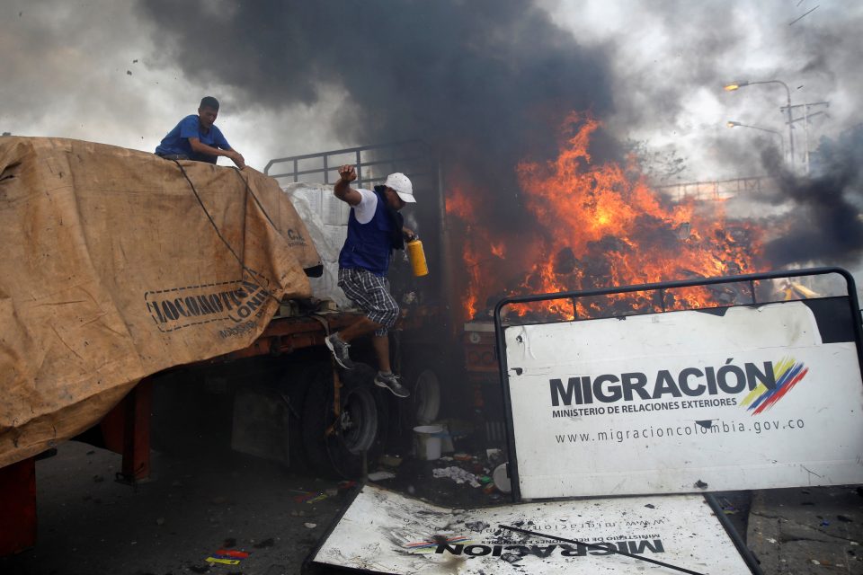 Nejméně jeden z kamionů s humanitární pomocí se u hranic s Kolumbií vznítil | foto: Marco Bello,  Reuters