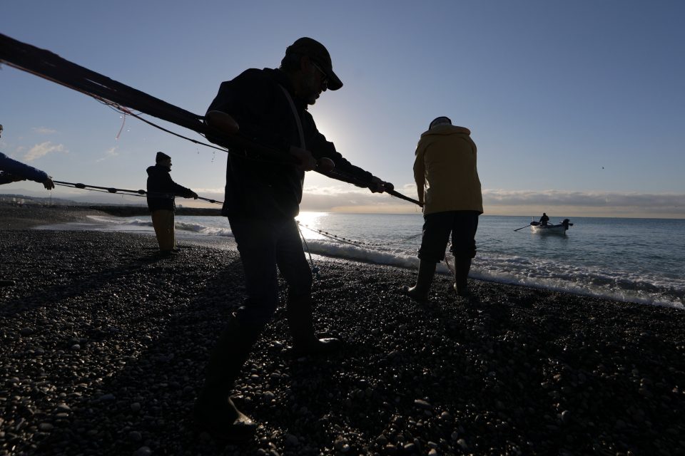 Rybáři natahují síť pro lov potěru. | foto: Eric Gaillard,  Reuters