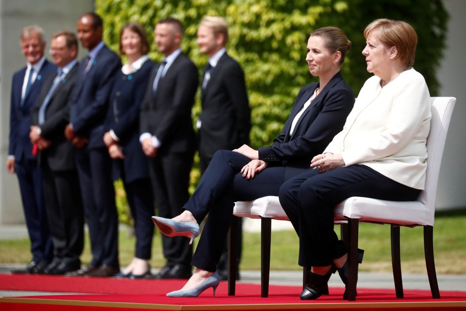 Dánská premiérka Mette Frederiksenová a německá kancléřka Angela Merkelová při hymnách obou zemí seděly | foto: Hannibal Hanschke,  Reuters