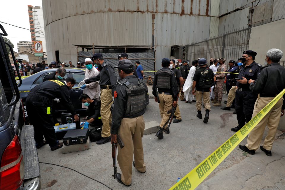 Policisté u pákistánské burzy v Karáčí,  kde zemřelo nejméně sedm lidí,  včetně všech čtyř ozbrojených útočníků. | foto: Akhtar Soomro,  Reuters